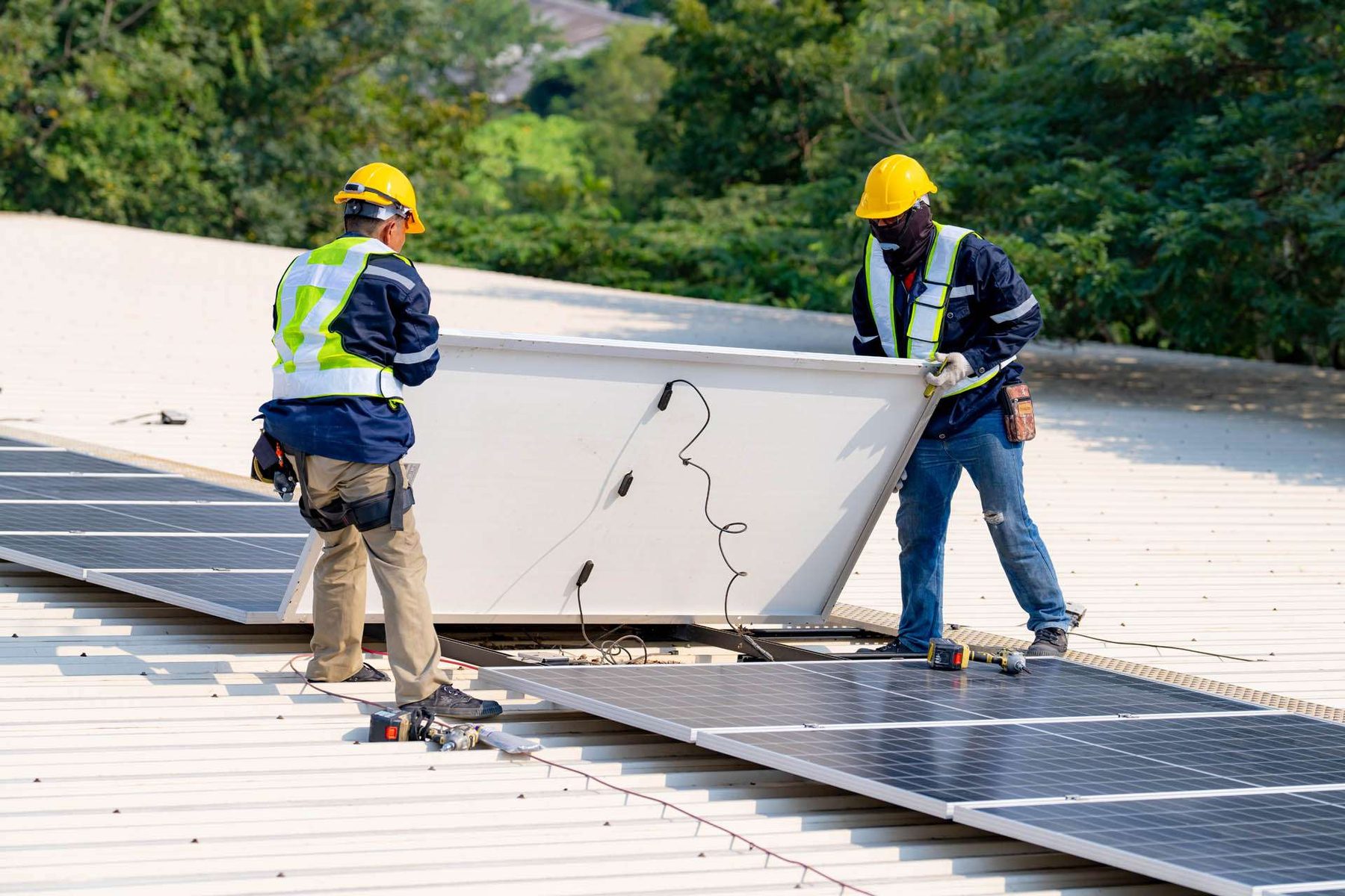 Crew removing a solar panel from a roof